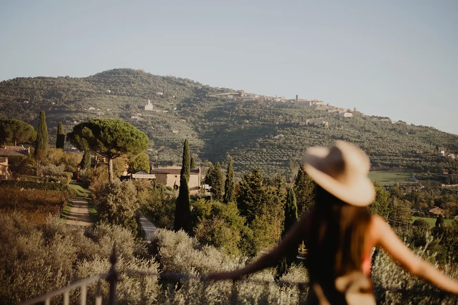 Ragazza di spalle su terrazza vista campagna Toscana