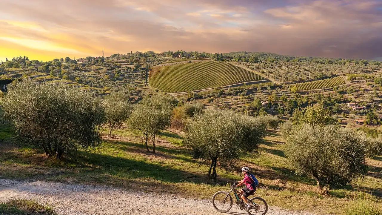 Donna in e-bike su colline toscane