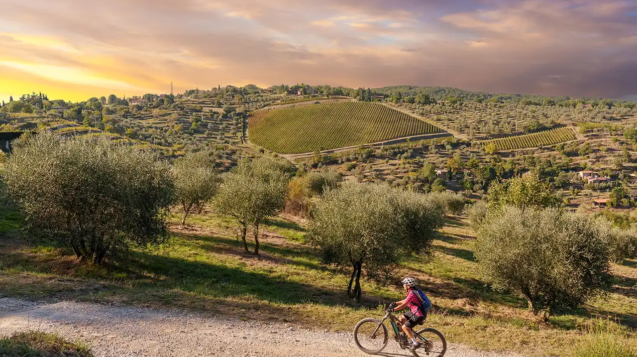 Donna in e-bike su colline toscane